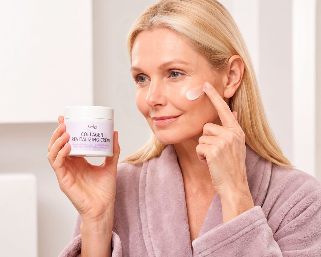 Woman applying collagen cream while holding Reviva Labs jar