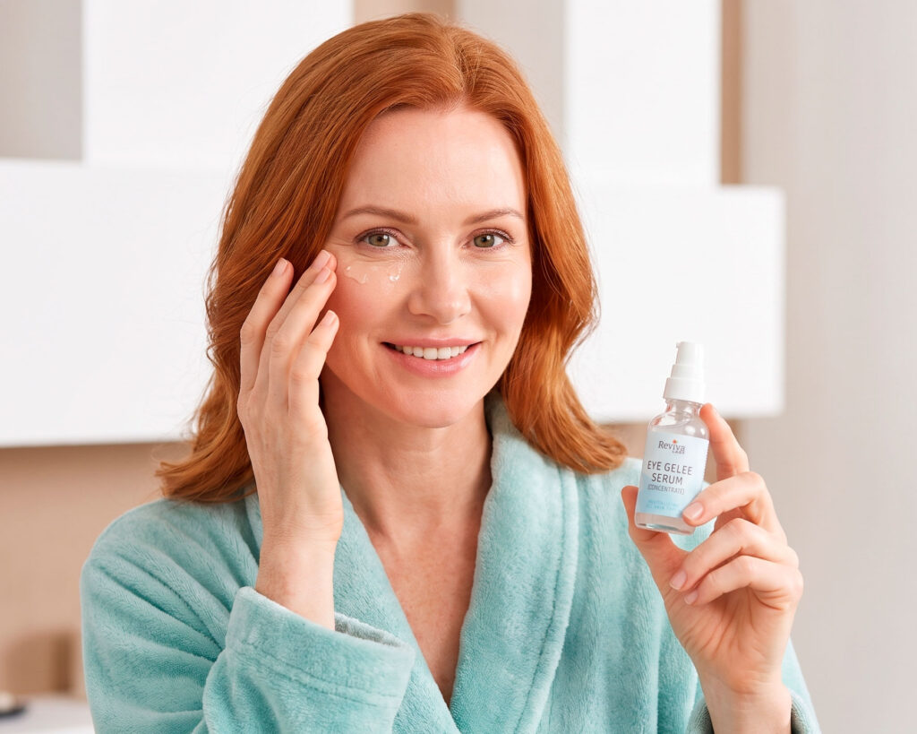 Woman applying eye serum while holding product bottle