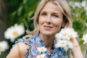 Smiling woman among white daisies in a garden